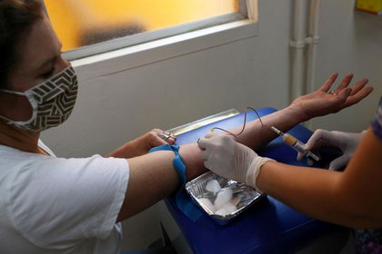 La corresponsal de Reuters Aislinn Laing recibe la dosis de una vacuna o un placebo durante un ensayo clínico de la vacuna de Johnson & Johnson contra el COVID-19, en la localidad de Colina, Santiago. Chile, 20 de noviembre de 2020. Fotografía tomada el 20 de noviembre. REUTERS/Ivan Alvarado