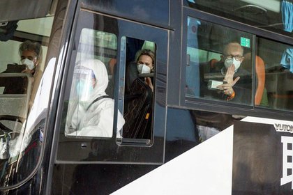 Miembros del equipo de la OMS encargados de investigar los orígenes de la pandemia de COVID-19 en un autobús mientras salen del aeropuerto internacional de Wuhan Tianhe en Wuhan, China, 14 enero 2021. (REUTERS/Thomas Peter)
