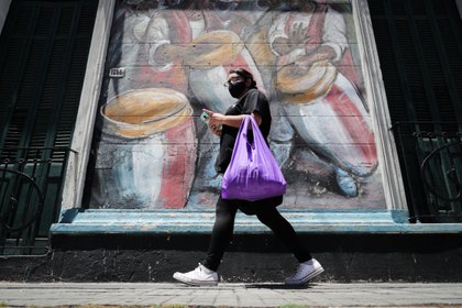 Una mujer pasa frente a un muro con un dibujo alusivo al candombe uruguayo, en Montevideo (Uruguay). EFE/Raúl Martínez/Archivo 