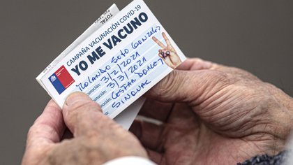 Un anciano mira su tarjeta de vacunación después de recibir una inyección de la vacuna CoronaVac para COVID-19 desarrollada por la compañía biofarmacéutica china Sinovac Biotech, en una clínica en Santiago, Chile, el miércoles 3 de febrero de 2021.
