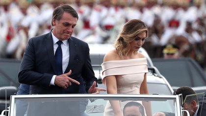 Jair Bolsonaro realiza su gesto característico simbolizando un arma al arribar a la ceremonia de asunción junto a su esposa Michelle (Reuters/Archivo)