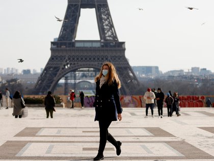 Una mujer, con máscaras protectoras, camina frente a la torre Eiffel en el Trocadero de París en medio del brote de la enfermedad del coronavirus (COVID-19) en Francia, el 11 de febrero de 2021. REUTERS/Sarah Meyssonnier