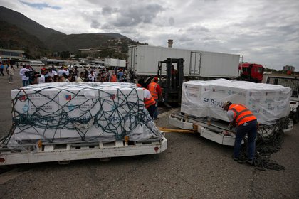 Trabajadores descargan el primer lote de la vacuna Sputnik V luego de su llegada al aeropuerto internacional de Maiquetía Simón Bolívar, en Caracas (REUTERS / Fausto Torrealba)