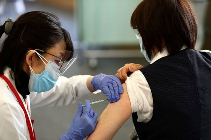 Una médica recibe una dosis de la vacuna contra COVID-19 mientras el país lanza su campaña de inoculación, en Tokio, Japón, el 17 de febrero de 2021. Behrouz Mehri/Pool vía REUTERS