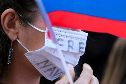 Una manifestante con una bandera rusa y una máscara con la consigna: "Liberen a Navalny". REUTERS/Ringo Chiu/File Photo/File Photo