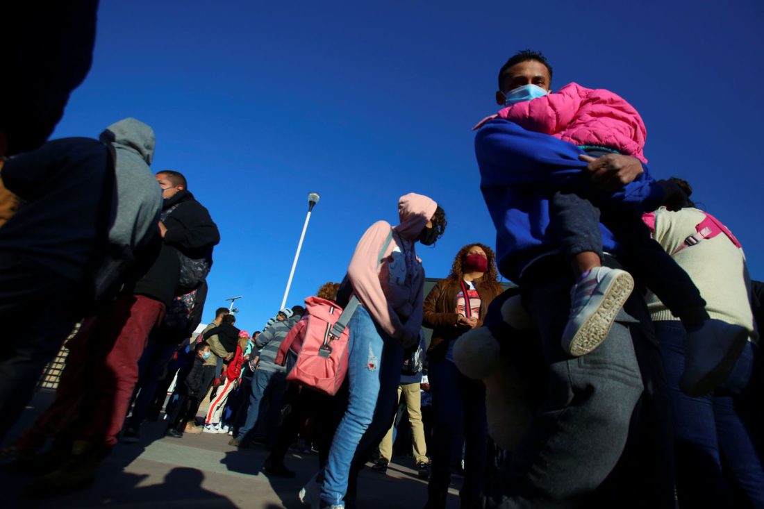 Migrantes hacen fila el viernes 19 de febrero en el puerto de entrada de El Chaparral, que divide Tijuana y San Diego.