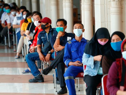 Personas con máscaras protectoras esperan para recibir una dosis de la vacuna Sinovac Biotech de China para la enfermedad del coronavirus (COVID-19) en el mercado textil de Tanah Abang, mientras Indonesia impulsa la vacunación masiva para los vendedores en Yakarta, Indonesia, el 17 de febrero de 2021. REUTERS / Ajeng Dinar Ulfiana