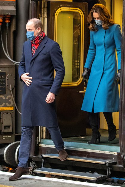 Wiilliam y Kate llegan en tren a la estación Waverley de Edimburgo en el segundo día de una gira de tres días por todo el país, en Escocia, Gran Bretaña, en diciembre de 2020. La extenuante gira fue una de las tantas responsabilidades que debió afrontar la pareja durante la pandemia (Reuters)