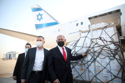 El primer ministro israelí Benjamin Netanyahu con un cargamento de vacunas Pfizer-BioNTech recien llegadas al país. Motti Millrod/Pool via REUTERS/File Photo