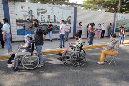 ersonas en sillas de ruedas hacen cola para votar durante las elecciones presidenciales y parlamentarias, fuera de un colegio electoral en Lima, Perú, 11 de abril de 2021. REUTERS/Sebastian Castaneda