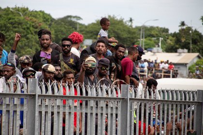 Esta foto tomada el 14 de marzo de 2021 muestra una multitud de personas sin máscaras faciales ni distanciamiento social, reunidas frente al Aeropuerto Internacional Jacksons en Port Moresby para despedirse del ataúd del primer primer ministro de Papúa Nueva Guinea, Michael Somare. (Foto de Andrew KUTAN / AFP)