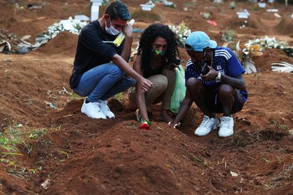 Familiares de víctima de Covid-19 lloran en entierro en cementerio de São Paulo (REUTERS/Amanda Perobelli)