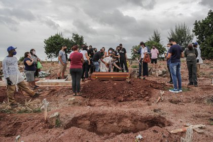 Familiares lloran la muerte por covid-19 de un ser querido, durante su entierro, el 13 de abril de 2021, en un cementerio del norte de Río de Janeiro (EFE/André Coelho) 
