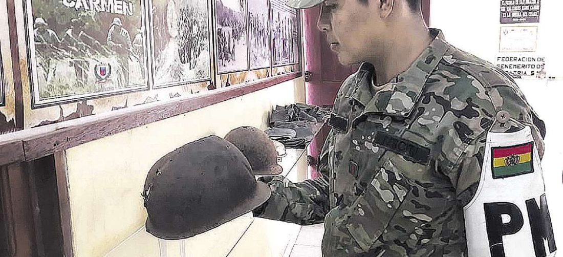 Un militar observa el casco utilizado por un benemérito en la guerra