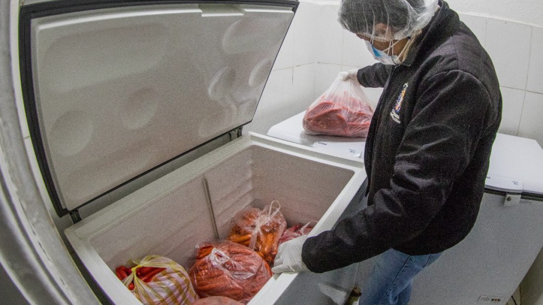 Un funcionario municipal revisa un refrigerador en unja empresa.
