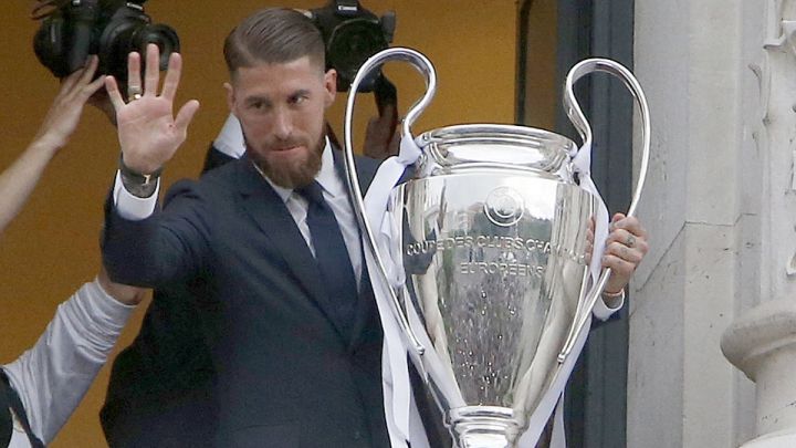 Sergio Ramos, con el trofeo de la Copa de Europa de una de las Champions que ha conquistado con el Real Madrid, saluda desde el balcón de la sede de la Comunidad de Madrid en la Puerta del Sol.