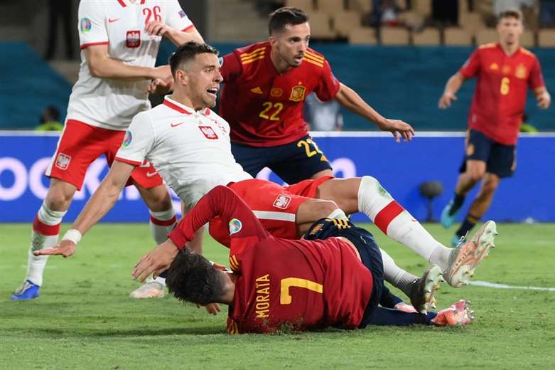 El defensor polaco Jan Bednarek (izq.) cae sobre el delantero español Álvaro Morata. /AFP