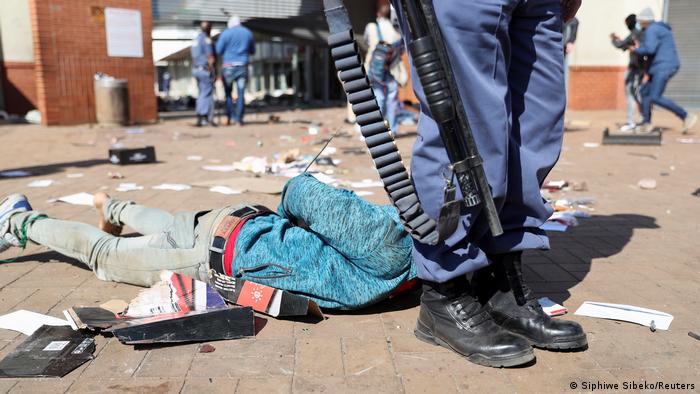Manifestante detenido, mientras continúan las protestas, tras el encarcelamiento del expresidente de Sudáfrica, Jacob Zuma, en Katlehong, Sudáfrica.
