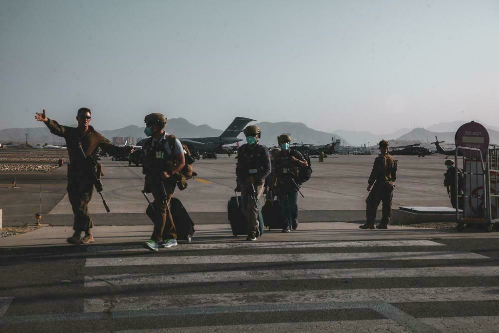 Un marine asignado a la 24ª Unidad Expedicionaria de Marines (MEU) escolta a personal del Departamento de Estado para ser procesado para su evacuación en el Aeropuerto Internacional Hamid Karzai, en Kabul, Afganistán, el domingo 15 de agosto de 2021.
