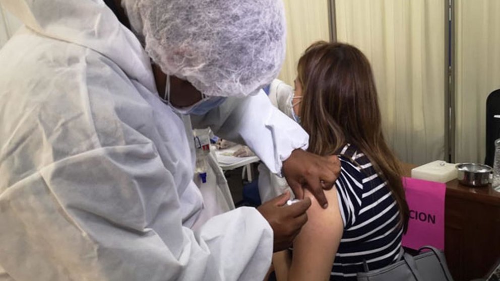 Personal de salud aplica la vacuna a una mujer. URGENTEBO