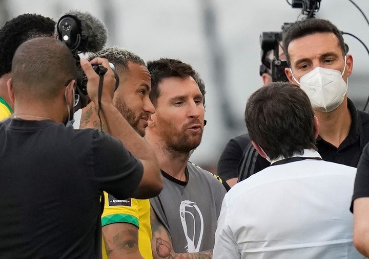 Lionel Messi y Lionel Scaloni discuten con representantes locales tras la interrupcion de Brasil-Argentina. Foto AP