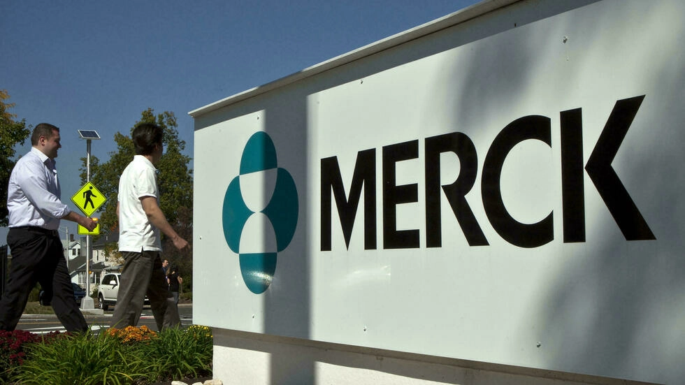 Empleados pasan frente a un cartel de laboratorio estadounidense Merck fuera de un edificio de la empresa en Summit, Nueva Jersey, Estados Unidos, el 2 de octubre de 2013