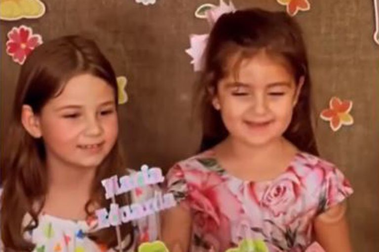 Las hermanas frente a una torta de cumpleaños, un año después