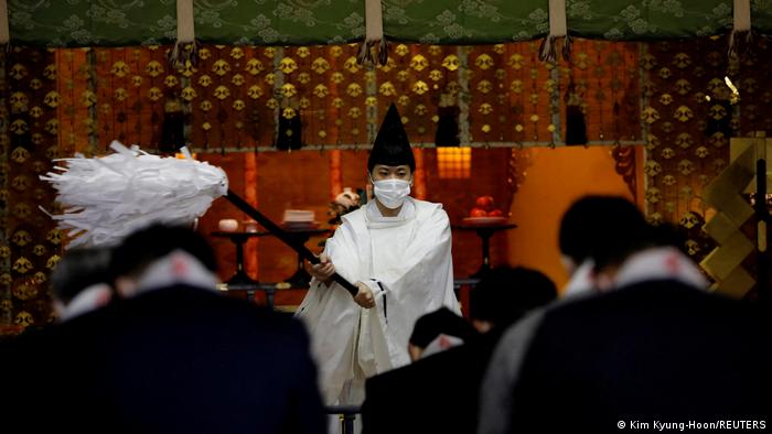 Sacerdote sintoísta con mascarilla preside una ceremonia en el santuario Kanda Myojin, en Tokio, donde fieles piden buena fortuna y negocios prósperos, en medio la pandemia de COVID-19. 