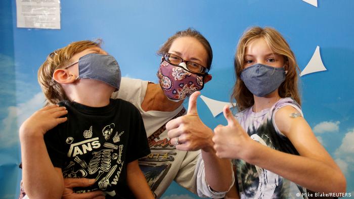 Una familia: madre, hijo e hija con mascarillas contra el coronavirus.