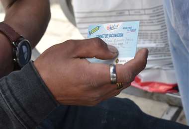 Una persona muestra su carnet de vacunación. Foto archivo: APG