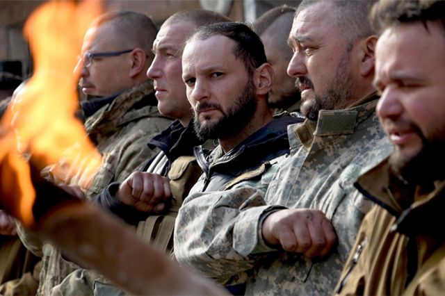 Soldados ucranianos rinden homenaje a uno de los suyos en un funeral militar.