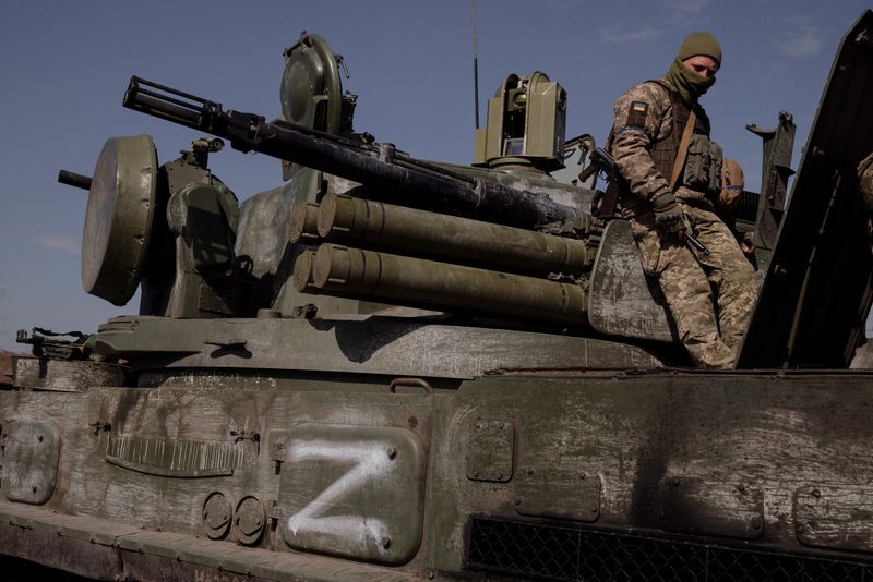 Un soldado ucraniano sentado sobre un vehículo armado ruso capturado marcado con el símbolo "Z", utilizado por las fuerzas de Vladimir Putin durante su invasión de Ucrania, en las afueras de Kiev, el 29 de marzo de 2022 (Reuters)