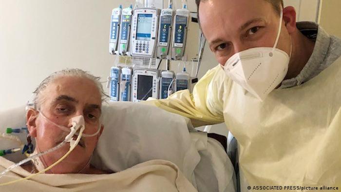 David Bennett Jr., a la derecha, junto a la cama de hospital de su padre en Baltimore, Maryland, el 12 de enero de 2022, cinco días después de que los médicos trasplantaran un corazón de cerdo a Bennett padre, en un último esfuerzo por salvar su vida.