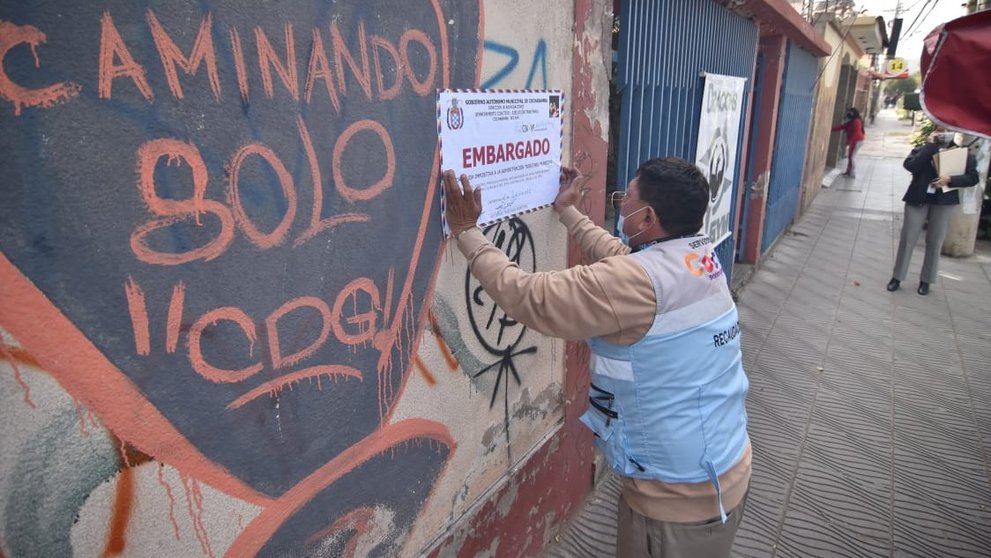 Personal municipal coloca el letrero de embargo en una propiedad en la avenida Aniceto Padilla, este 1 de junio. NOÉ PORTIGAL
