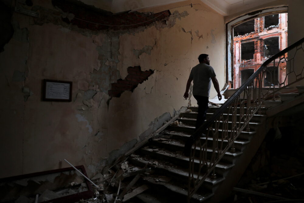 Un hombre sube las escaleras dentro de un edificio de la Universidad Nacional de Kharkiv destruido por los ataques de Rusia en Kharkiv, el 3 de junio de 2022 (Reuters)