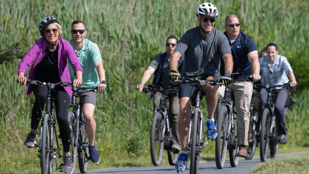 Joe Biden paseando en bicicleta con la primera dama, Jill Biden (SAUL LOEB / AFP)