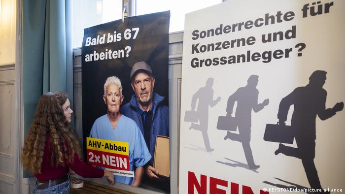 Una joven pega publicidad para votar no a la reforma de pensiones en Suiza.