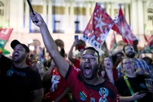 Seguidores del expresidente brasileño Luiz Inacio Lula da Silva, quien vuelve a postularse para presidente, escuchan los resultados parciales luego del cierre de las urnas para las elecciones generales en Río de Janeiro