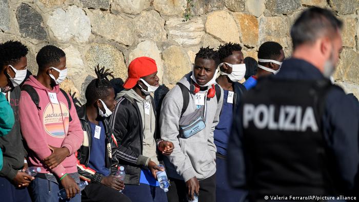 Migrantes que llegaron con el barco Rise Above de la ONG alemana Mission Lifeline esperan ser atendidos en Reggio Calabria, Italia