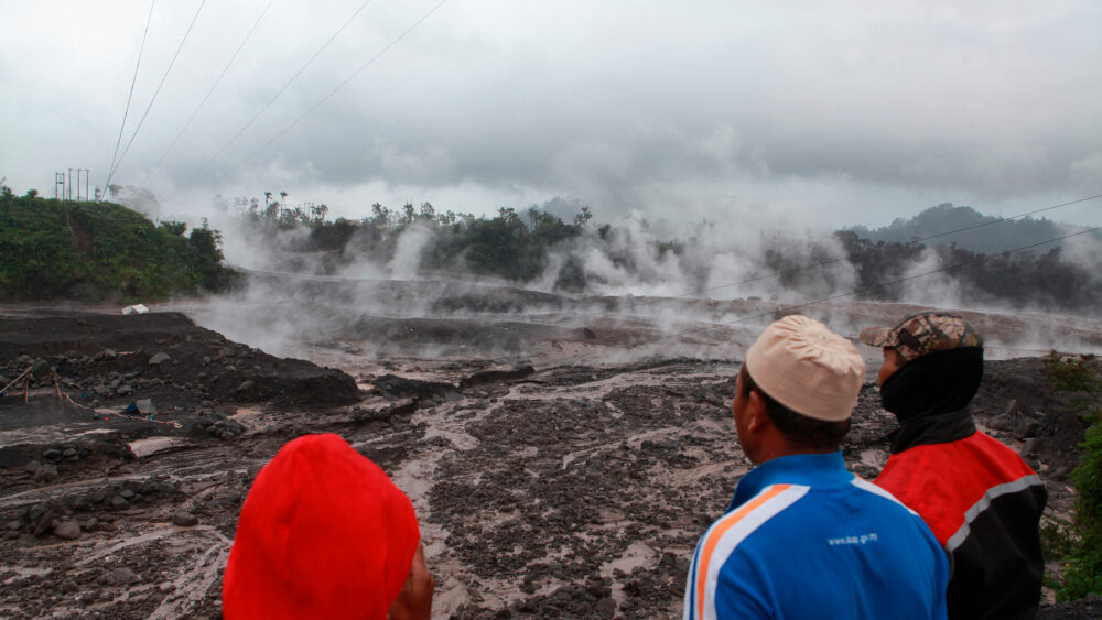 Los aldeanos observan el humo caliente del suelo luego de la erupción volcánica del Monte Semeru en Lumajang, Java Oriental, el 4 de diciembre de 2022. (Foto de PUTRI / AFP) 