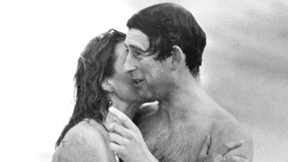 El príncipe Carlos es besado por Jane Priest, una modelo, mientras emerge del agua en la playa de Cottesloe en Perth, durante su gira de 1979 por Australia. (Foto de © Hulton-Deutsch Collection/CORBIS/Corbis vía Getty Images)