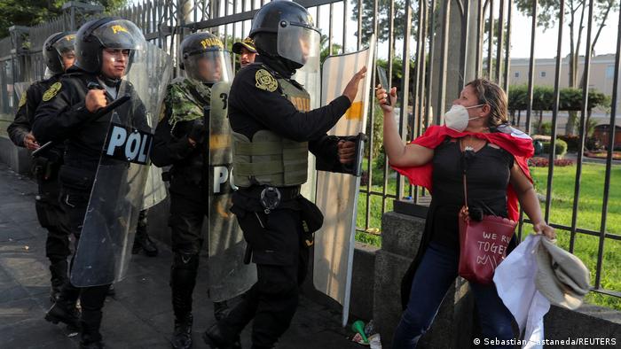 Foto de archivo de una persona que es rodeada por policías antimotines durante una protesta en Perú.