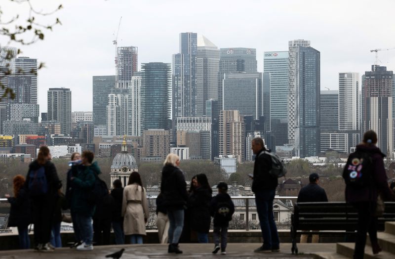 La gente mira desde el parque de Greenwich, con el distrito financiero de Canary Wharf en la distancia, en Londres, Reino Unido. REUTERS/Henry Nicholls