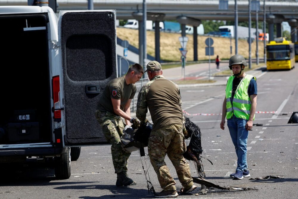 Oficiales recogen restos de un bombardeo para liberar una carretera (REUTERS/Valentyn Ogirenko)