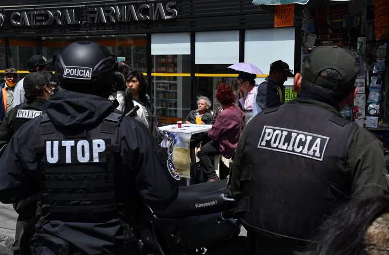 Policías observan la acción de Amparo Carvajal. Foto: APG. 