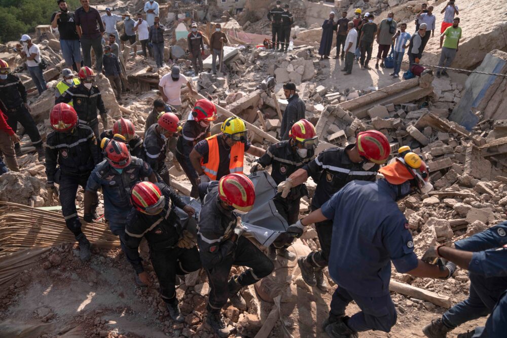 Un equipo de rescate extrae el cuerpo de una mujer, muerta durante el terremoto, en la población de Imi N'tala (AP Foto/Mosa'ab Elshamy)