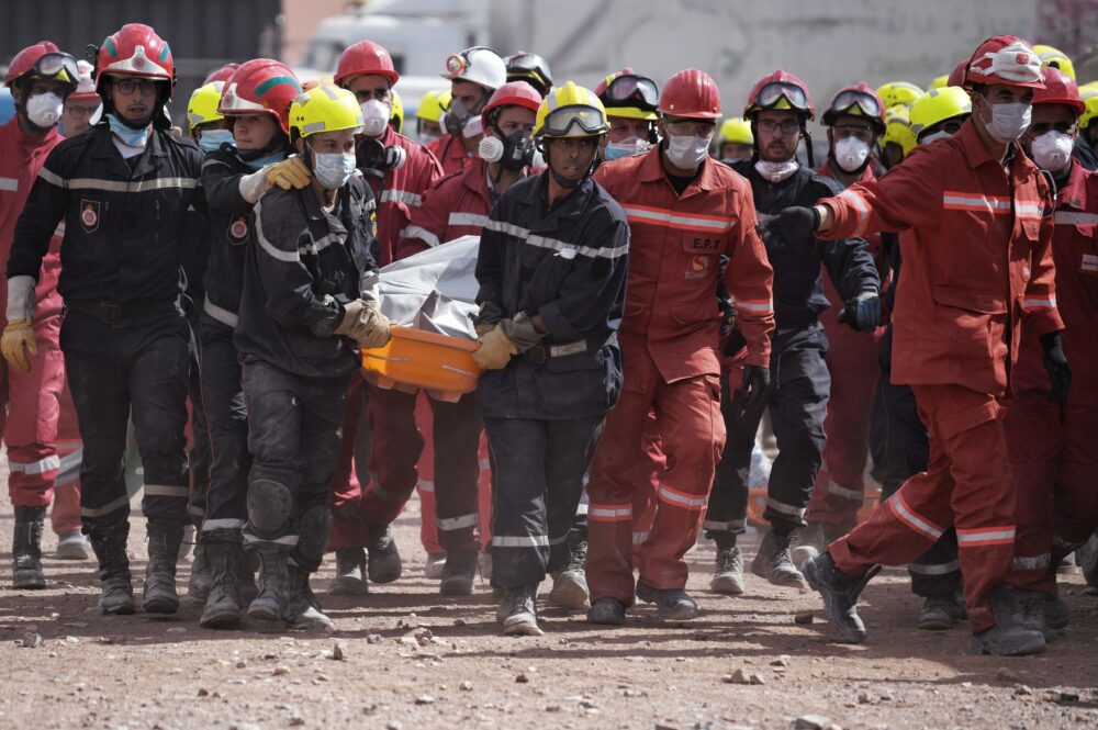 Un grupo de bomberos lleva el cuerpo de una persona fallecida (Foto: Europa Press)