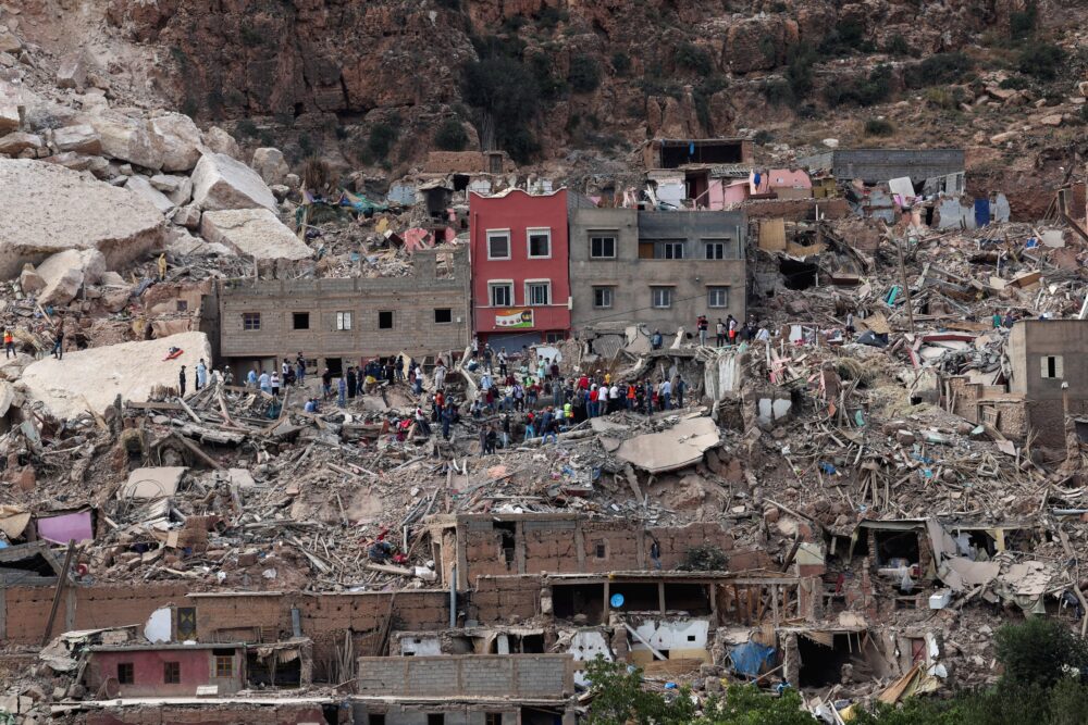 Un grupo de personas sobre los escombros del pueblo de Imi N'Tala (REUTERS/Emilie Madi)