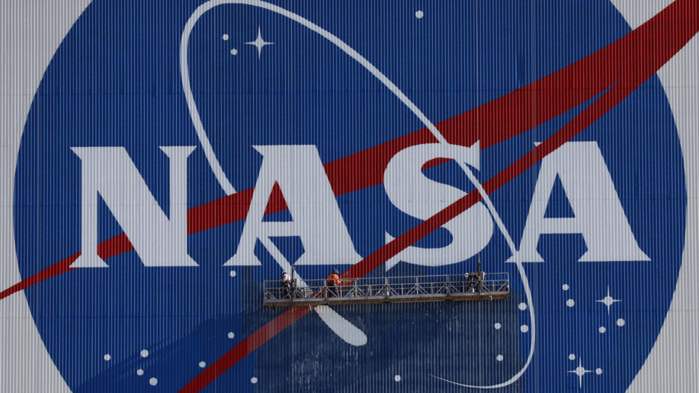 Unos pintores rtocan el logotipo de la NASA en el Centro Espacial Kennedy, en Florida (EEUU), el 29 de mayo de 2020