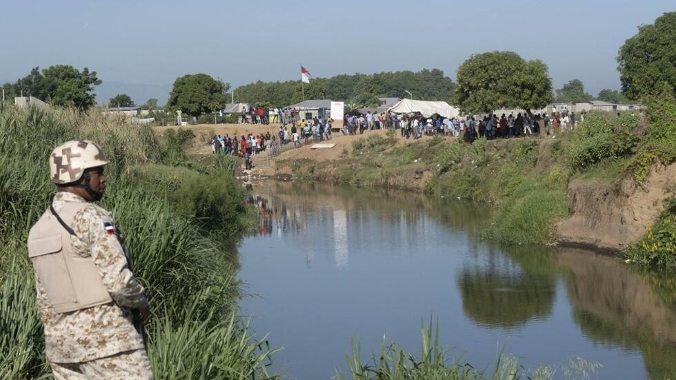 Un soldado de República Dominicana permanece en la orilla del Río Masacre, frontera natural con Haití, río abajo de la construcción de un canal en el lado haitiano, en Dajabón, el 15 de septiembre de 2023.